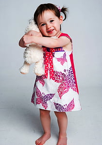 girl wearing dress hugging hear plush toyt thumbnail