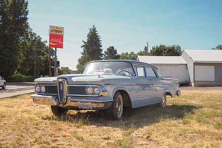 vintage blue coup parked on brown soil thumbnail