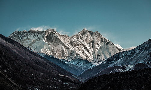 mountain covered white snow under blue sky thumbnail