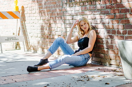 woman sitting on floor beside paver brick wall thumbnail