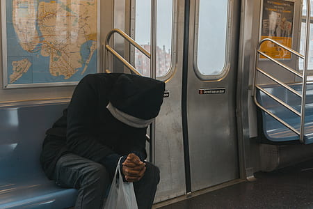 Person in Black Hoodie Sitting on Train Bench thumbnail