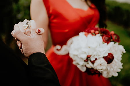 woman wearing red dress holding man's hand thumbnail