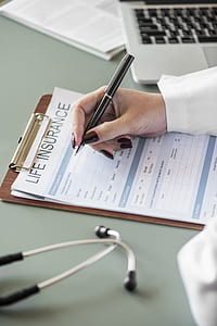 selective focus photography of person holding pen thumbnail