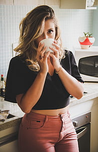 woman holding teacup leaning on sink thumbnail