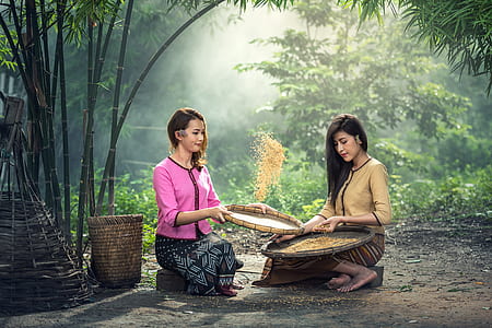 two woman sitting on stones holding basket thumbnail