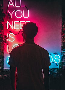 man wearing white shirt standing in front of LED signage thumbnail