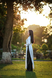 woman in white dress standing near tree thumbnail