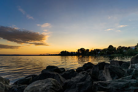 rocks near body of water during sunset thumbnail
