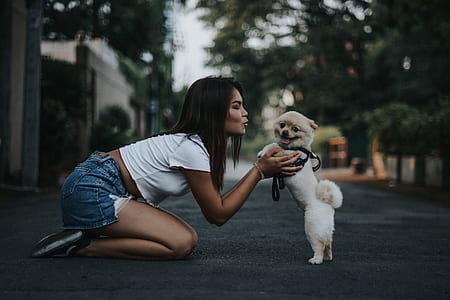 woman holding and kissing Pomeranian thumbnail