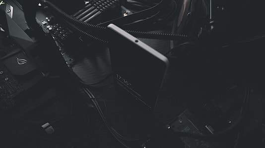 black smartphone beside black cables thumbnail