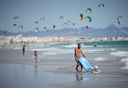 man holding blue inflatable bed on seashore thumbnail