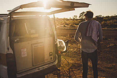 man standing near open rear door vehicle thumbnail