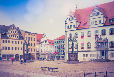 people standing near white and red concrete building thumbnail