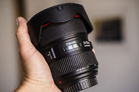 person holding Canon camera lens thumbnail