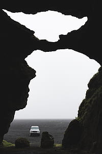 white SUV on sand near rocky mountain thumbnail