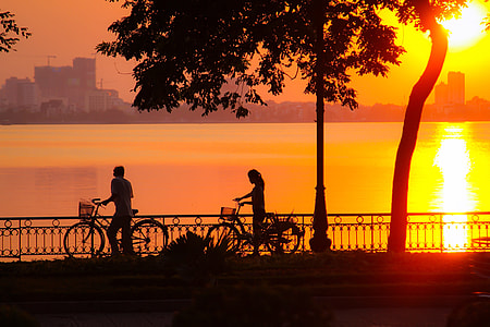 Sunset and 2 cyclists in Hanoi, Vietnam thumbnail