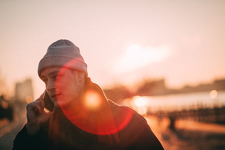 selective focus photography of man holding phone thumbnail