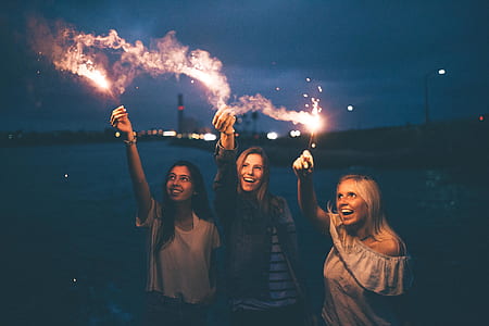 two women raising lighted sparklers thumbnail