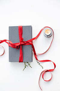 gray book with red ribbon beside votive candle thumbnail