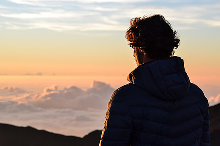 A man at the top of the mountains enjoying the view above the clouds thumbnail