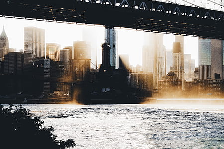 suspension bridge across on body of water near high-rise buildings thumbnail