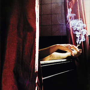 person holding a cigarette while on bath tub thumbnail