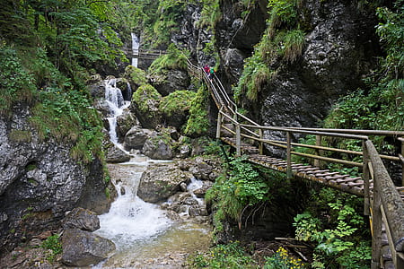 brown wooden bridge near waterfalls thumbnail