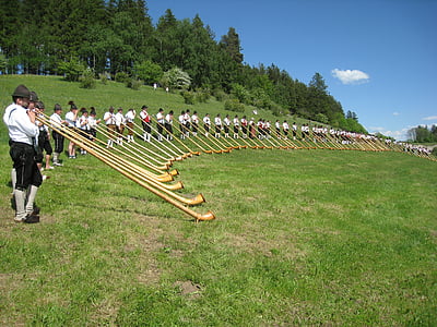 group of people standing and holding horns on the green grass thumbnail