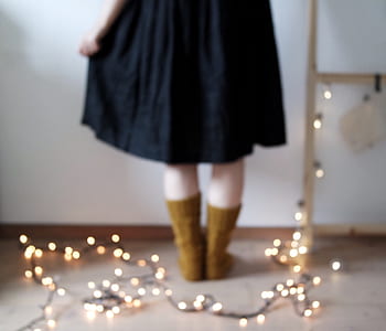 woman standing beside string lights thumbnail