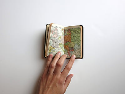person opening a booklet of map thumbnail