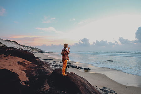 man standing on rock during daytime thumbnail
