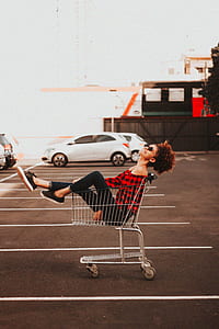 woman happily sitting inside shopping cart thumbnail