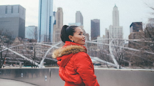 woman in orange parka jacket in shallow focus shot thumbnail