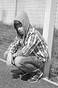 man wearing hoodie leaning on fence thumbnail