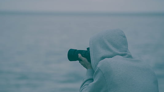 person taking photo of sea using black DSLR camera thumbnail