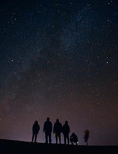 silhouette of five people under sky with stars photo taken during nighttime thumbnail