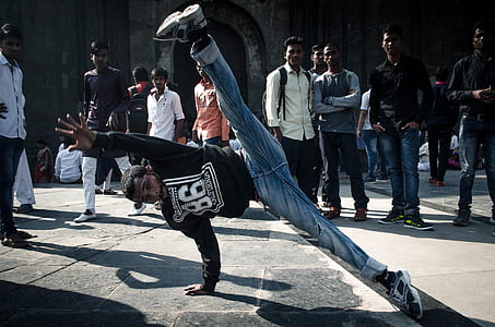 group of people watching man in black shirt break dancing thumbnail