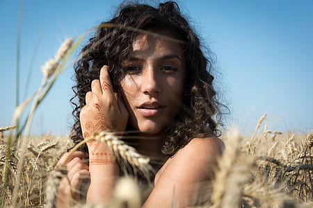 black haired woman standing in the middle of wheat during day time thumbnail