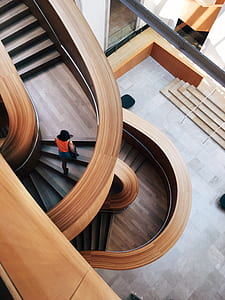 person in orange shirt taking step on brown wooden stairs thumbnail