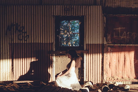 photography of woman in white in abandoned house during daytime thumbnail