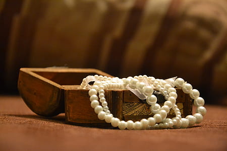 beaded gray necklace on brown wooden case thumbnail