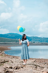 Woman Holding Balloons Near River thumbnail