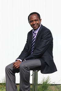 man in suit jacket and gray dress pants outfit sitting on gray stainless steel chair at daytime thumbnail