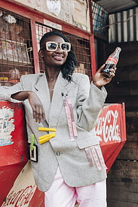 Woman Smiling While Holding Bottle of Coca-cola thumbnail
