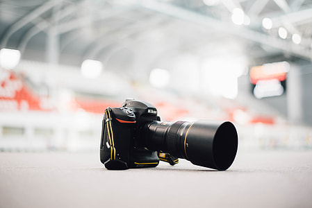 selective focus photography of black Nikon DSLR camera on ground thumbnail