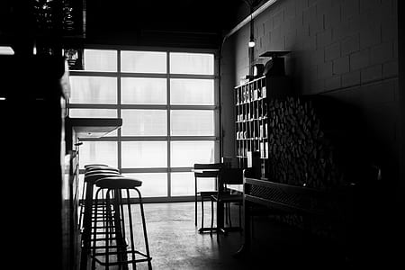 grayscale photo of bar counter with round barstools thumbnail