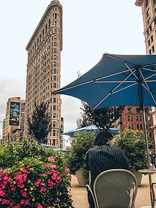 person sitting on armchair under the umbrella during daytime thumbnail