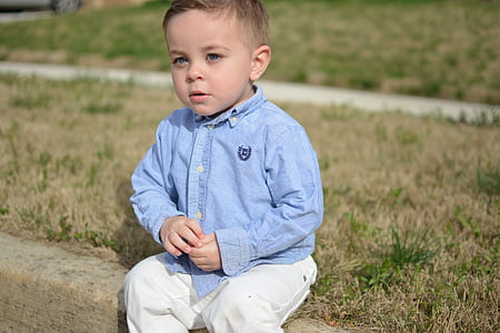 boy sitting on driveway curb thumbnail