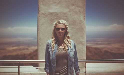 woman standing near gray stainless steel railings during daytime thumbnail