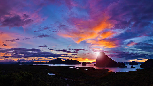 silhouette of mountain surrounded by water thumbnail